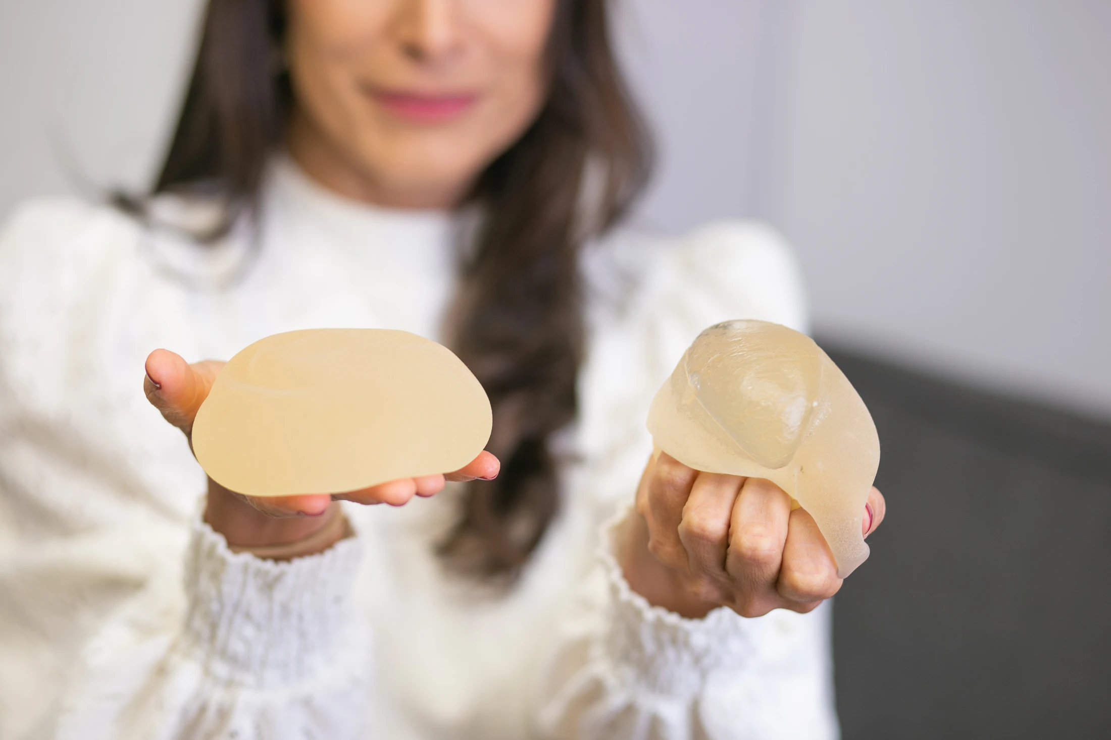 Dra. Taís apresentando modelos de prótese de mama durante a consulta
